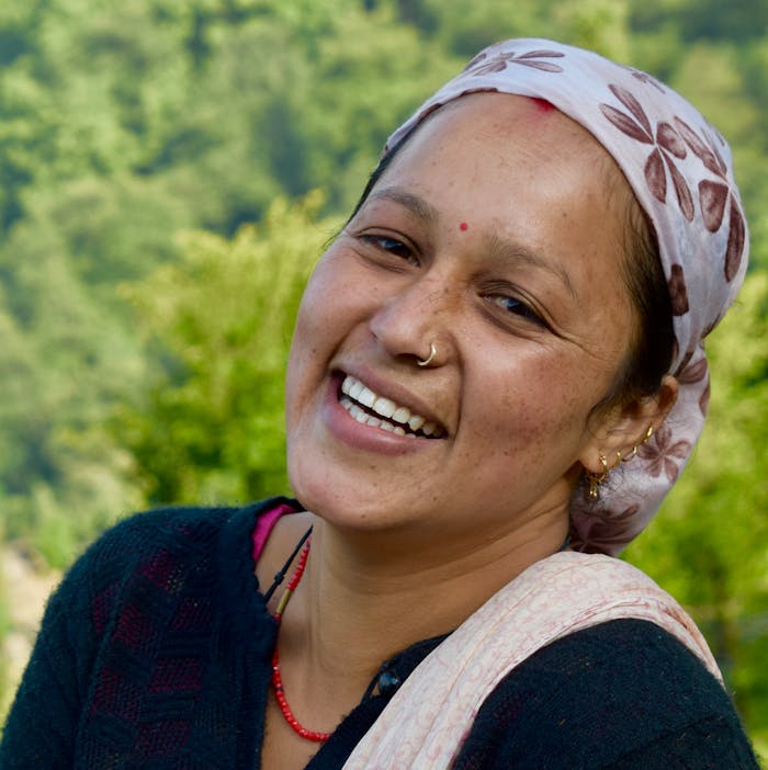 portfolio-img-03 A cheerful woman with a nose piercing smiling in a vibrant outdoor setting in India.
